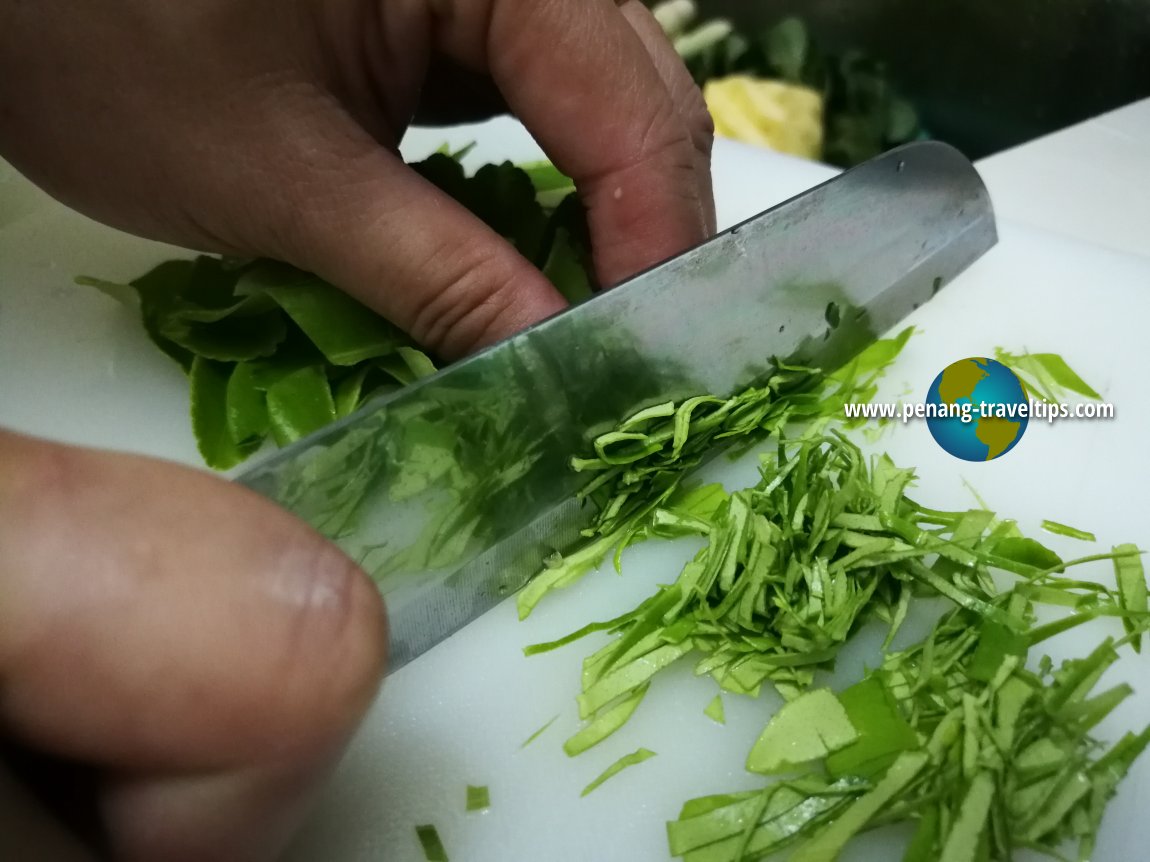 Slicing the kaffir lime leaves for Perut Ikan