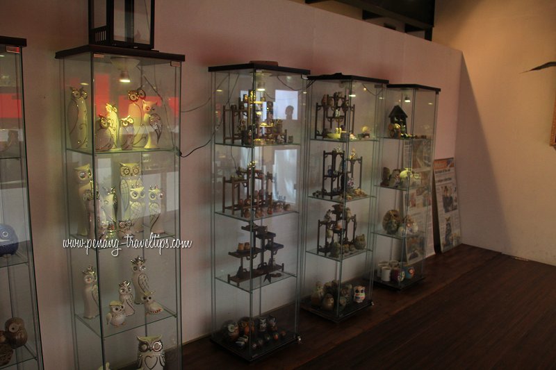 More owl figurines in glass display cases