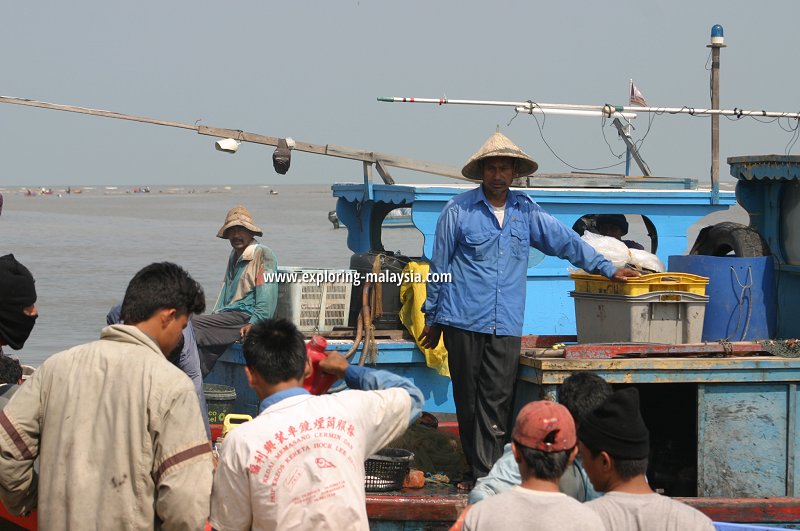 Fishermen and fishmongers crowd around