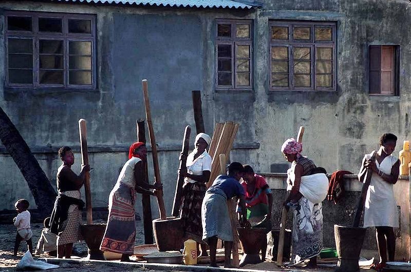 Women pounding and husking rice in Beira, Mozambique