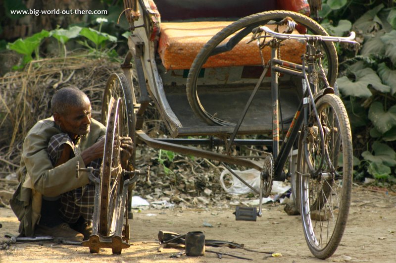 An old man repairing the wheel of his rickshaw in Sarnath