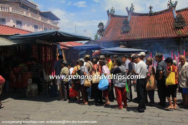 People lining up to receive food donation in front of Kuan Im Teng