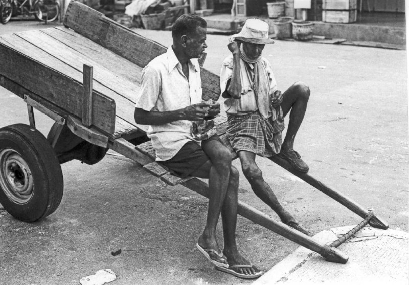 Indian coolies resting on a pull cart