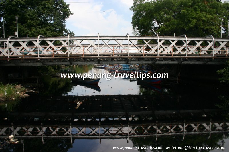 The ink-black waters of Sungai Pinang with the old steel truss Sungai Pinang Bridge