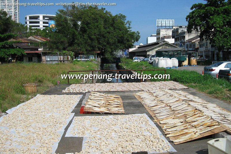 Salted fish being dried above the covered Prangin Canal